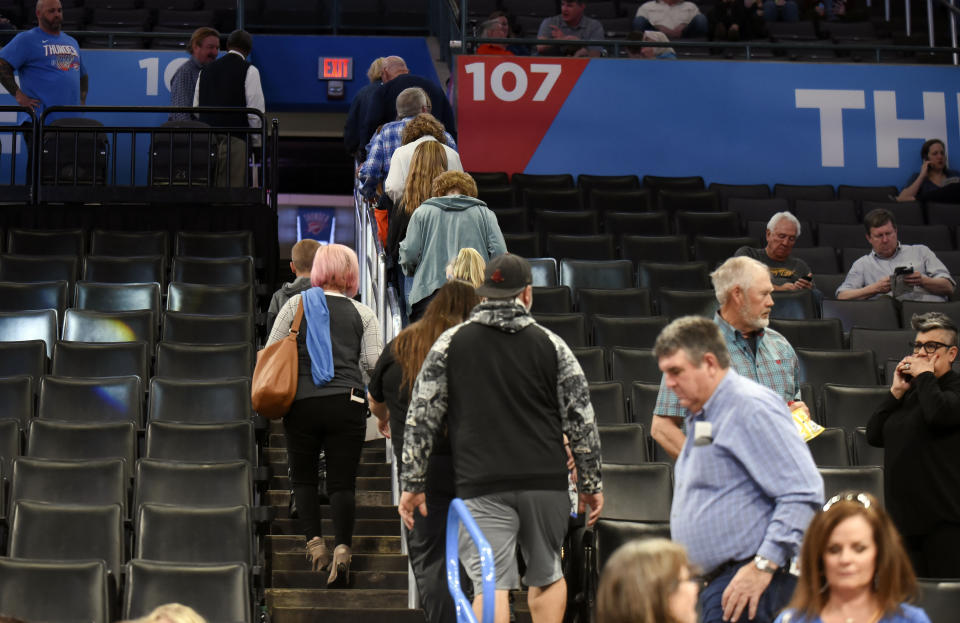 Basketball fans leave Chesapeake Energy Arena after it is announced that an NBA basketball game between Oklahoma City Thunder and Utah Jazz in Oklahoma City has been postponed, Wednesday, March 11, 2020. (AP Photo/Kyle Phillips)