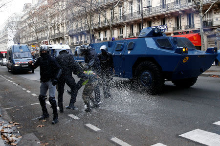 French Gendarmes apprehend a protester as they advance with armoured vehicles during clashes at a demonstration during a national day of protest by the "yellow vests" movement in Paris, France, December 8, 2018. REUTERS/Stephane Mahe