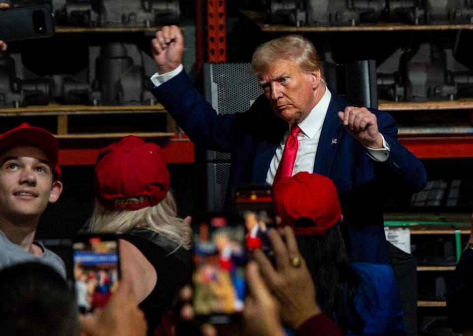 Former US President and 2024 presidential hopeful Donald Trump gestures while speaking at Drake Enterprises, an automotive parts manufacturer and supplier, in Clinton, Michigan (AFP via Getty Images)