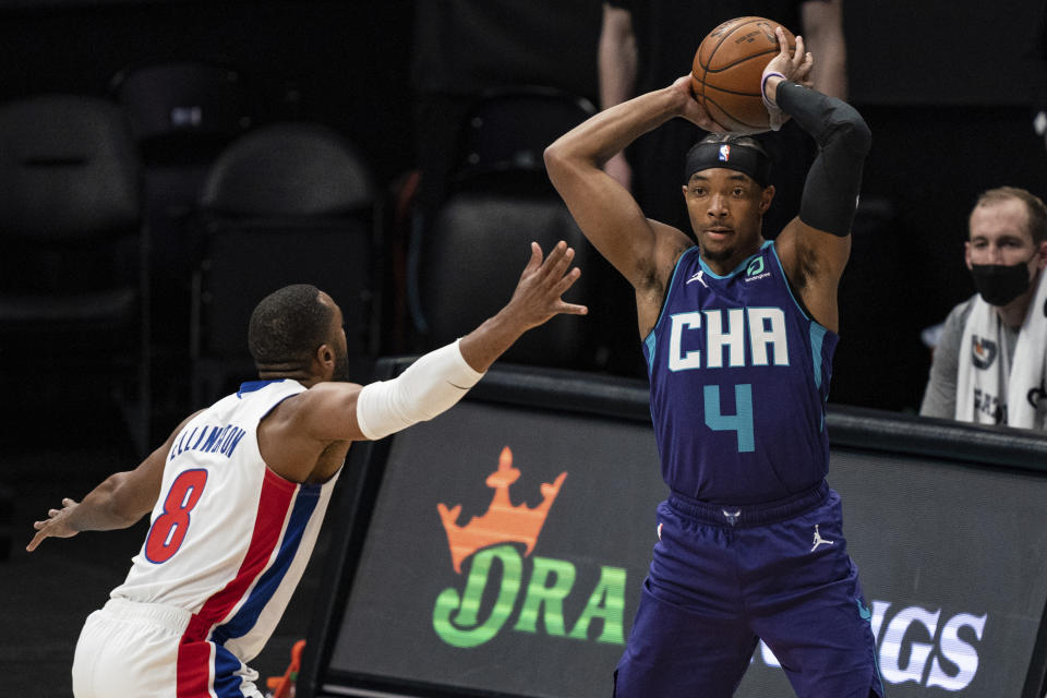 Charlotte Hornets guard Devonte' Graham (4) looks to pass the ball past Detroit Pistons guard Wayne Ellington (8) during the first half of an NBA basketball game in Charlotte, N.C., Thursday, March 11, 2021. (AP Photo/Jacob Kupferman)
