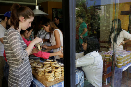 Volunteers of the Make The Difference (Haz La Diferencia) charity initiative prepare soup and fill in arepas to be donated, at the home kitchen of one of the volunteers in Caracas, Venezuela March12, 2017. REUTERS/Marco Bello