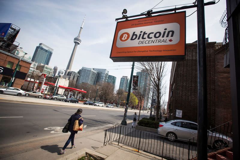 FILE PHOTO: People walk by a "Bitcoin Decentral" sign in Toronto