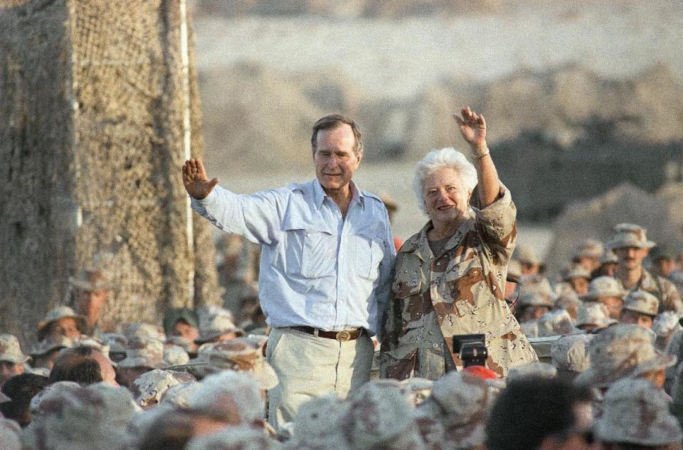 FILE - In this Nov. 22, 1990, file photo, President George H.W. Bush and first lady Barbara Bush wave to U.S. Marines during a Thanksgiving visit at the desert encampment in Saudi Arabia. Both Bushes have been hospitalized this week in Houston, where the former president is being treated for pneumonia and his wife for bronchitis. (AP Photo/Scott Applewhite, File)