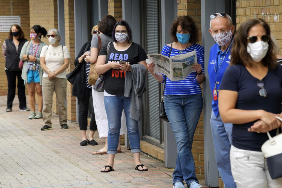 FILE - In this Sept. 18, 2020 file photo, Alexandria residents wait in a socially distance line to cast their ballots for the November presidential election on first day of early voting in Virginia, at the Voter Registration Office in Alexandria, Va. A severed fiber optic cable shut down Virginia's online voter registration system Tuesday, Oct. 13 the last day to register before the November general election. The Virginia Department of Elections said in statement on Twitter that a “fiber cut” was affecting connectivity for multiple agencies, including the citizen portal and registrar's offices, and technicians were working to repair the problem. (John McDonnell/The Washington Post via AP, File)