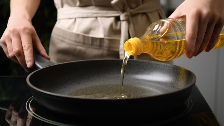 person pouring oil into pan