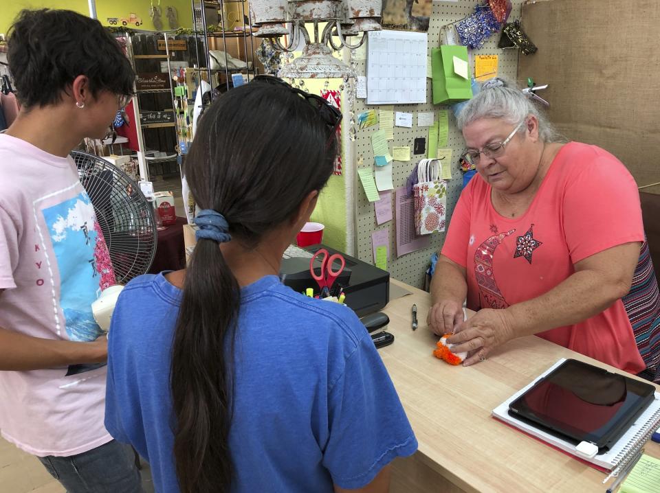 Shopkeeper Patty Lane, right, helps customers at gift shop along the main street in Truth or Consequences, New Mexico, on Monday, July 12, 2021. Lane is among the residents who are hopeful that more economic benefits will begin to trickle down to local businesses following Richard Branson's flight with his Virgin Galactic crewmates from nearby Spaceport America. (AP Photo/Susan Montoya Bryan)