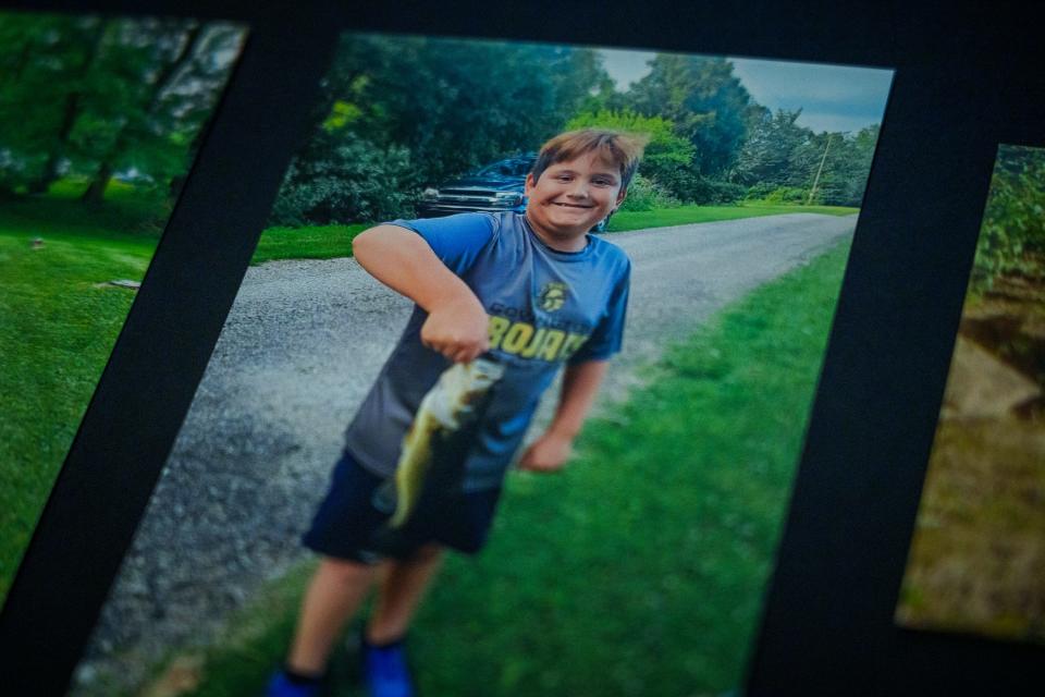 A photo shown Thursday, March 23, 2023, of Terry Badger III holding a bass is attached to a poster board that was used during his funeral. Badger III died by suicide March 6, 2023. According to his family, Badger III loved being outside and enjoyed most sports.