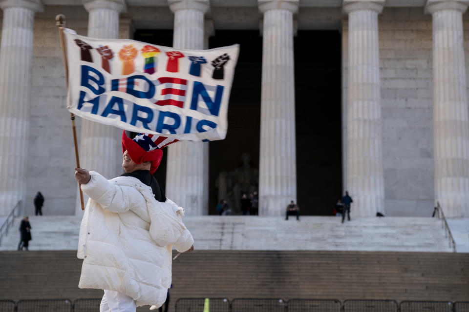 A supporter waves a Biden-Harris flag near the Lincoln Memorial in Washington, DC. 