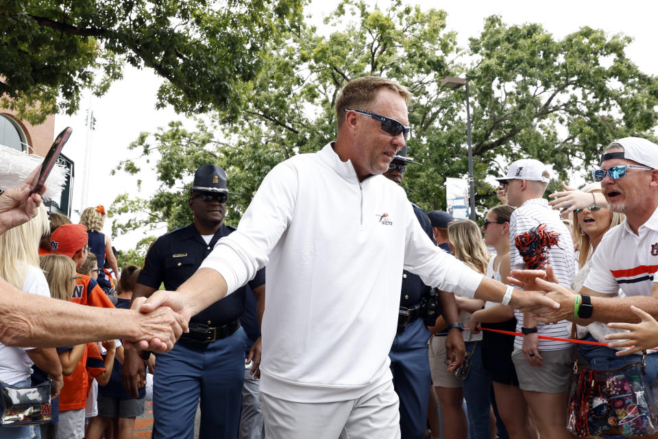 Auburn head coach Hugh Freeze greets fans as he walks to the stadium in his first Tiger Walk before an NCAA college football game against Massachusetts Saturday, Sept. 2, 2023, in Auburn, Ala. (AP Photo/Butch Dill)