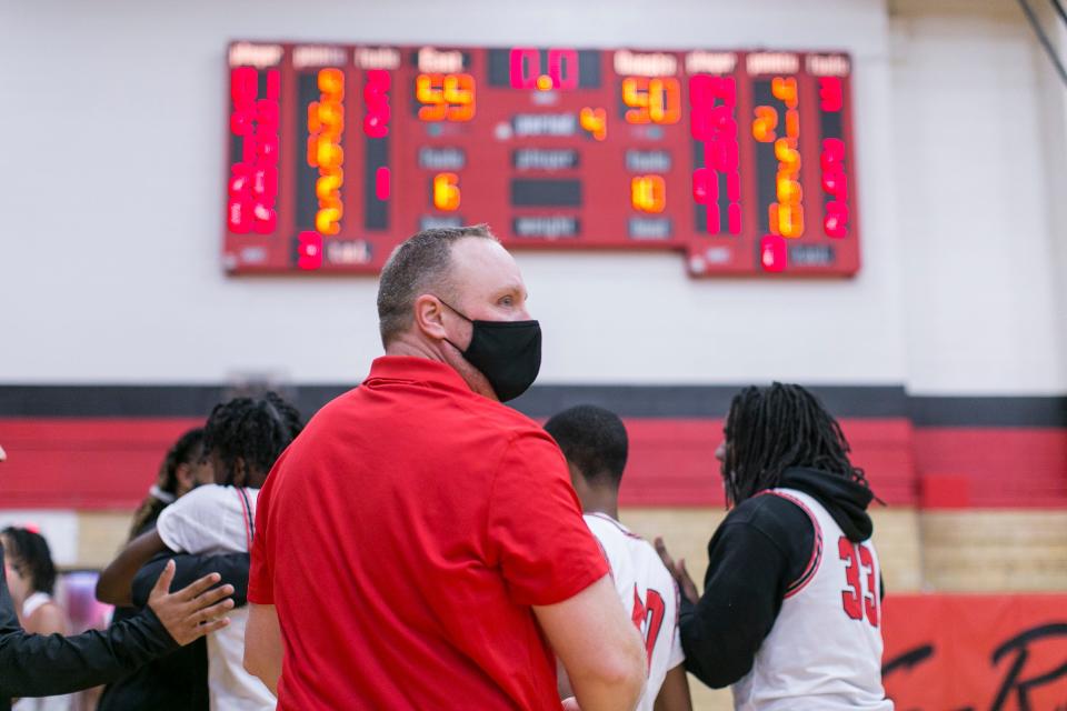 East boys basketball coach Roy Sackmaster and his team celebrate their 59-50 win over Harlem at East High School Friday, March 12, 2021, in Rockford.