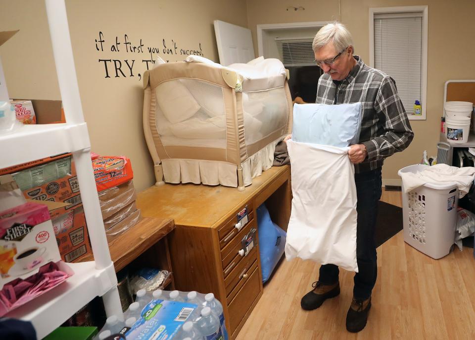 Roland Arper, site manager of the severe weather shelter at Port Orchard United Methodist Church, puts a clean case on a pillow as he gets the shelter ready to open on Wednesday.