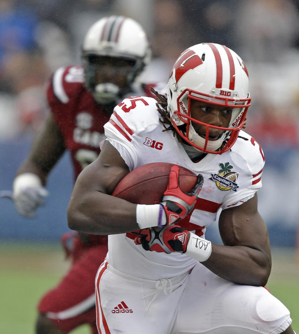 Wisconsin running back Melvin Gordon, front, runs for yardage past the South Carolina defense during the first half of the Capital One Bowl NCAA college football game in Orlando, Fla., Wednesday, Jan. 1, 2014.(AP Photo/John Raoux)