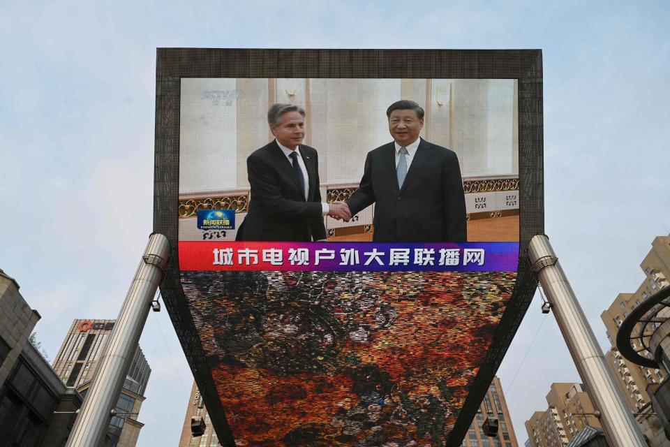 A broadcast shows footage of US Secretary of State Antony Blinken (L) meeting with China's President Xi Jinping, on a giant screen outside a shopping mall in Beijing on June 19, 2023.