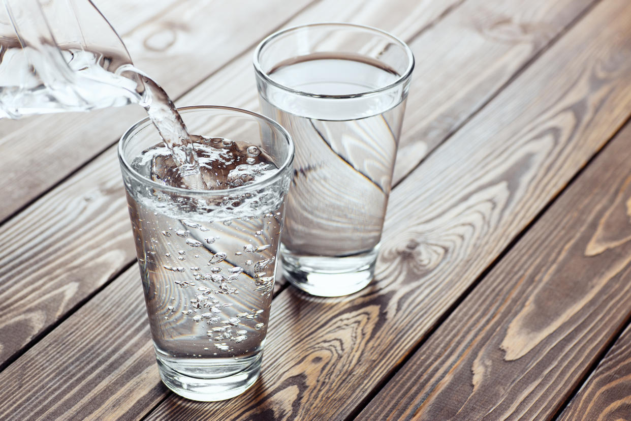 drinking water pouring from jug into glass on the table