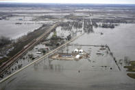 FILE- In this April 12, 2019 file photo, the flooded town of Pacific Junction, Iowa, is seen from above. Nebraska, Iowa, Kansas and Missouri are joining forces for a study that will look for ways the states can limit flooding along the Missouri River and give them information about how wetter weather patterns could require changes to the federal government's management of the basin's reservoirs. The states are pooling their money to pay for half of a $400,000 study with the U.S. Army Corps of Engineers to measure how much water flows down the Missouri River. (AP Photo/Nati Harnik)