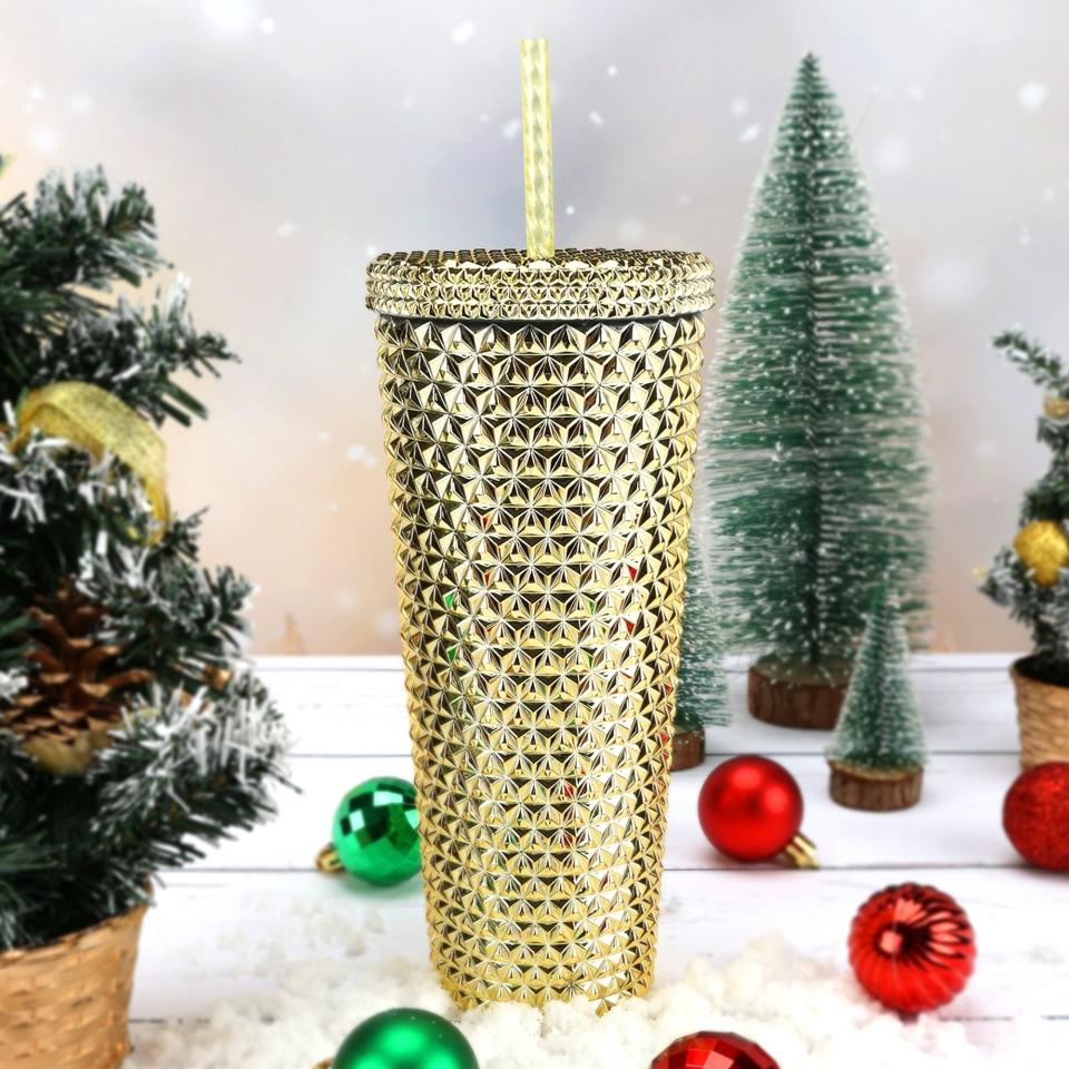 a gold tumbler with straw