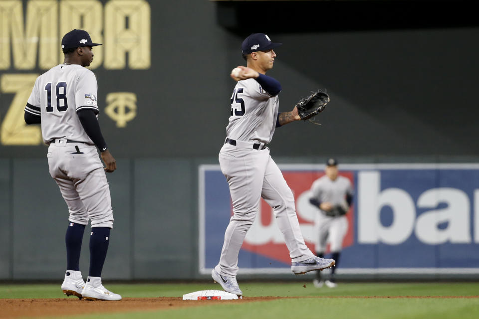 New York Yankees second baseman Gleyber Torres, right, throws to first base in front of teammate Didi Gregorius, left, during a double play in the first inning in Game 3 of a baseball American League Division Series, Monday, Oct. 7, 2019, in Minneapolis. (AP Photo/Bruce Kluckhohn)