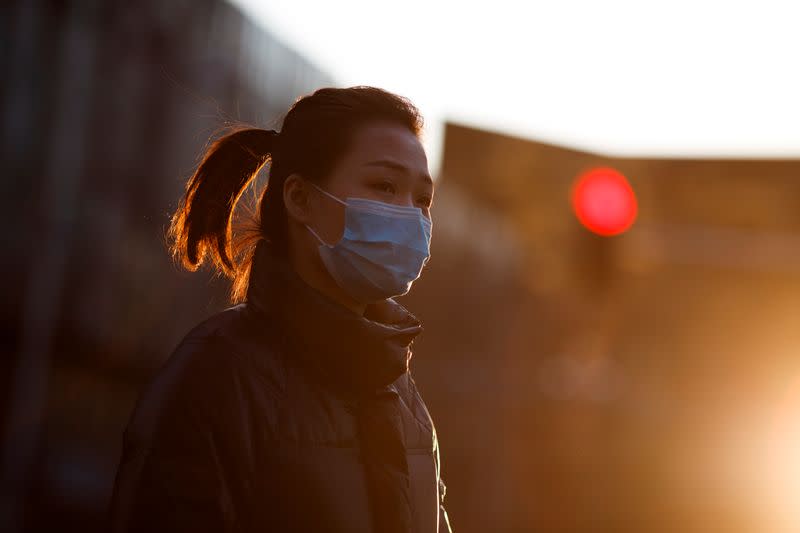 A woman wears a mask during evening rush hour in Beijing as the country is hit by the outbreak of the novel coronavirus in Beijing