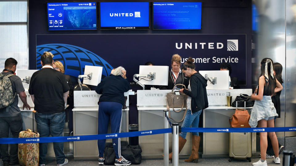 People line up to check their baggage at a United counter.<p>Image source: Robert Alexander/Getty Images</p>