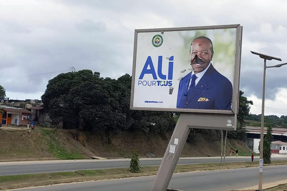 A defaced billboard of Gabon President Ali Bongo Ondimba is seen on an empty street of Libreville, Gabon, Wednesday Aug. 30, 2023. Mutinous soldiers speaking on state television announced that they had seized power in and were overturning the results of a presidential election that was to extend the Bongo family's 55-year hold on power. (AP Photo/Yves Laurent)
