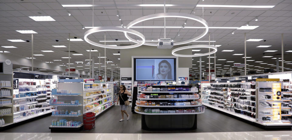 In this May 30, 2018, photo, a shopper walks through the updated cosmetic department at a Target store in San Antonio. Success of specialty chains like Sephora and Ulta has pushed discounters like Walmart and Target as well as drugstores like CVS to revamp their cosmetics areas with more open spaces, brighter lighting and more attractive fixtures. (AP Photo/Eric Gay)