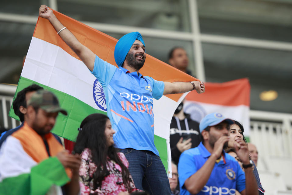 An Indian fan holds a flag during the third day of the World Test Championship final cricket match between New Zealand and India, at the Rose Bowl in Southampton, England, Sunday, June 20, 2021. (AP Photo/Ian Walton)