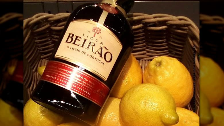 Bottle of alcohol in basket of lemons 