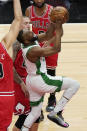 Boston Celtics guard Kemba Walker, right, drives to the basket past Chicago Bulls center Nikola Vucevic, front left, and center Daniel Theis, back left, during the first half of an NBA basketball game in Chicago, Friday, May 7, 2021. (AP Photo/Nam Y. Huh)