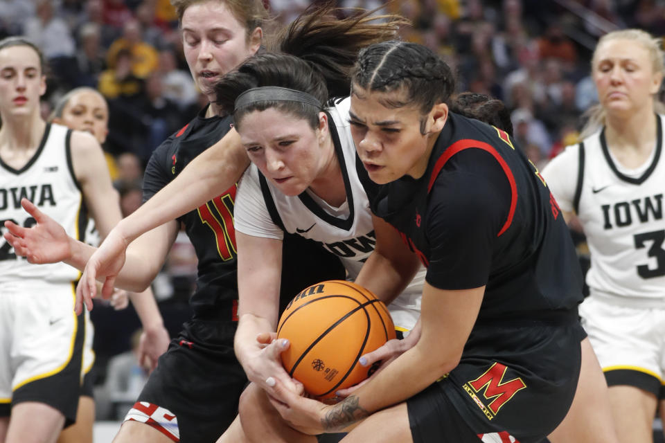 Iowa guard McKenna Warnock, center, vies for a rebound with Maryland guards Lavender Briggs, right, and Faith Masonius, left, in the second half of an NCAA college basketball game at the Big Ten women's tournament Saturday, March 4, 2023, in Minneapolis. Iowa won 89-84. (AP Photo/Bruce Kluckhohn)
