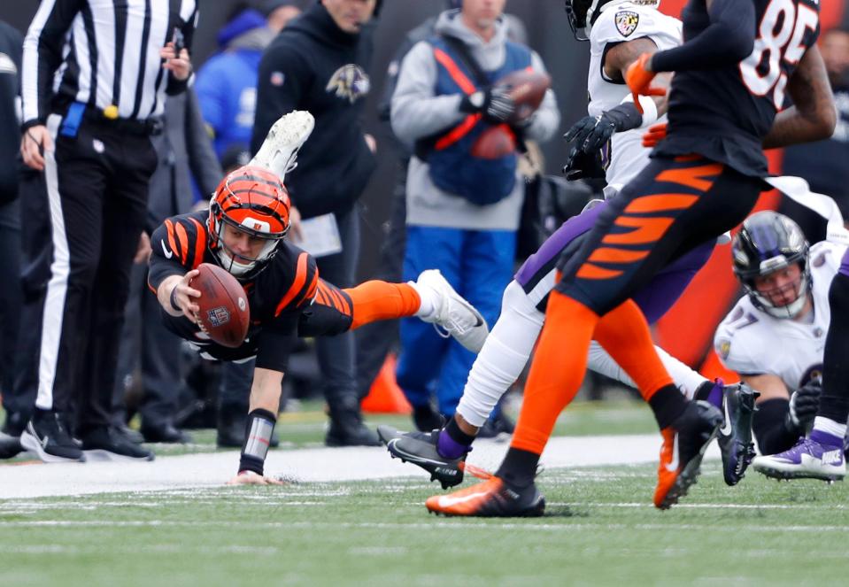 Cincinnati Bengals quarterback Joe Burrow (9) dives for a first down during the second quarter against the Baltimore Ravens at Paycor Stadium.