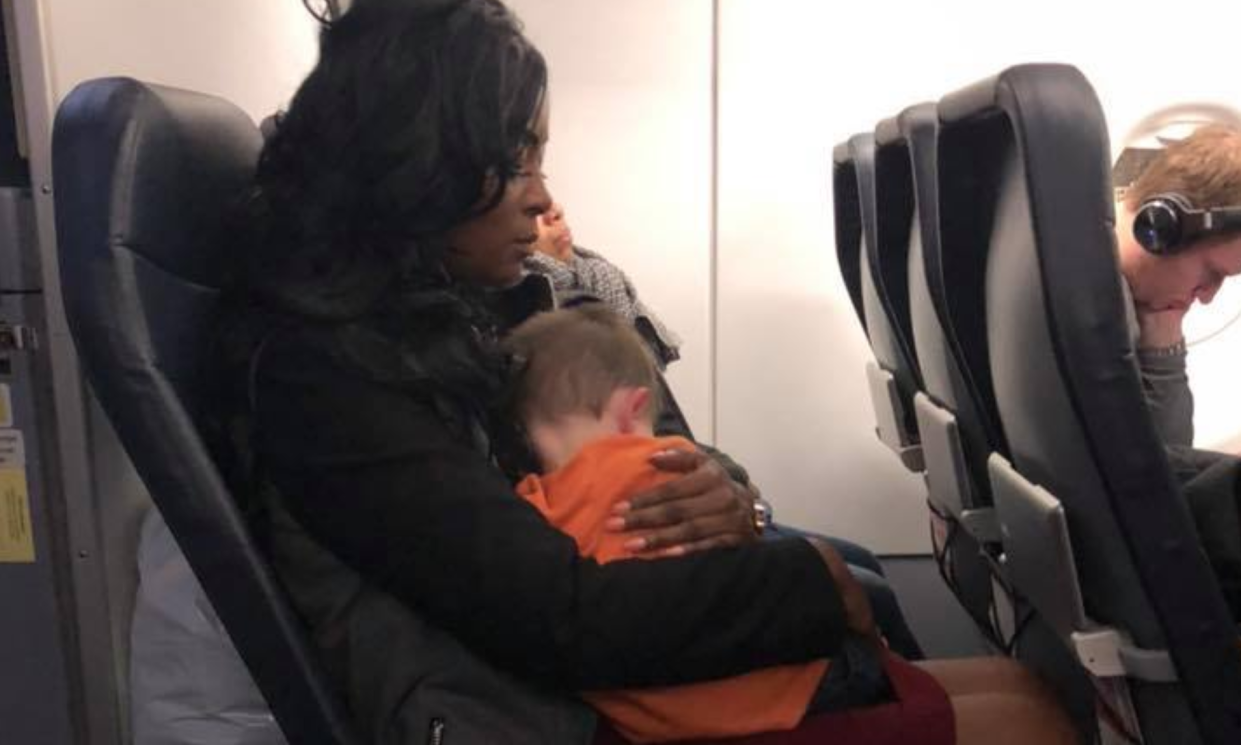 Three women, including this lovely passenger holding Becca Kinsey’s son Wyatt, stepped in to help make the family’s flight home more manageable. (Photo: Becca Kinsey via Facebook)