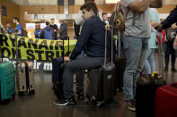 Spanish passengers wait for their flight to Malaga, Spain, in front of Ryanair airline check-in desks during a Ryanair employees strike at the Charleroi airport, outside Brussels, Belgium, Friday, Sept. 28, 2018. Ryanair pilots and cabin crew went on strike forcing the cancellation of some 250 flights across Europe, including Spain, Portugal, Belgium, the Netherlands, Italy and Germany.(AP Photo/Francisco Seco)