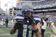 Seattle Seahawks wide receiver Jaxon Smith-Njigba is on his phone after an NFL football game against the Arizona Cardinals Sunday, Oct. 22, 2023, in Seattle. The Seahawks won 20-10. (AP Photo/John Froschauer)