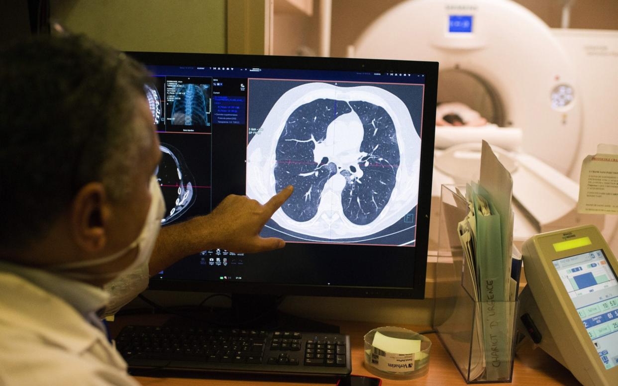 A doctor examines a patient's lungs - Nathan Laine /Bloomberg