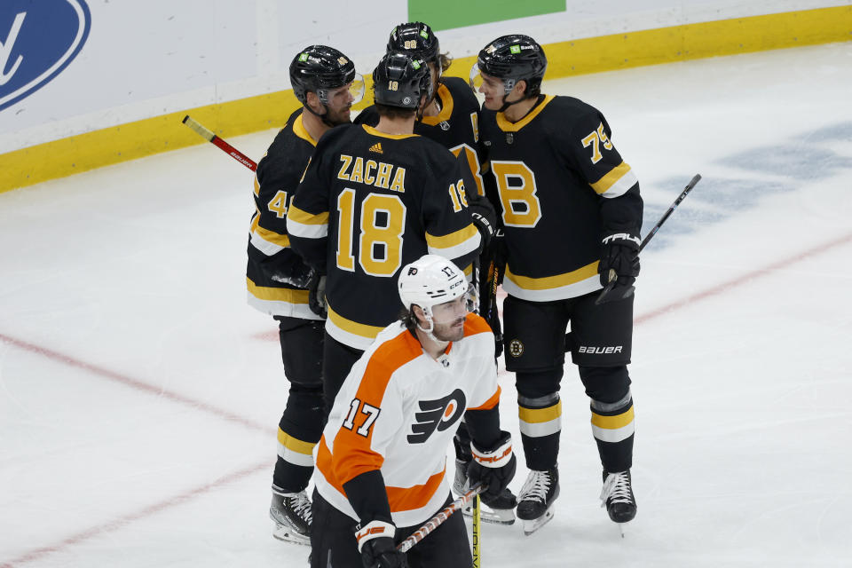 Philadelphia Flyers center Zack MacEwen skates away as Boston Bruins players congratulate Pavel Zacha (18) after he scored a goal during the second period of an NHL hockey game, Monday, Jan. 16, 2023, in Boston. (AP Photo/Mary Schwalm)