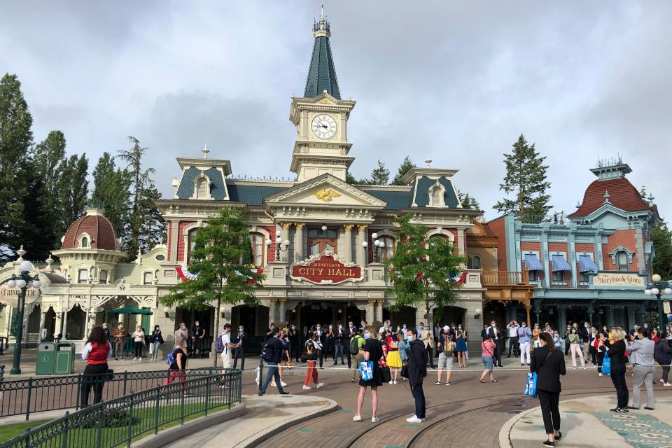 Visitors wait to enter Disneyland Paris on June 17, 2021. (AP Photo/Catherine Gaschka)