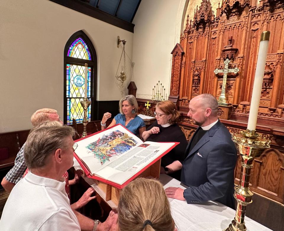 St. John’s Episcopal Church clergy and other church leaders are sharing The Saint John’s Bible with a group of parishioners in the church sanctuary ahead of launching "Year of the Bible" with a 72-hour Miqra reading starting Aug. 2, 2023.