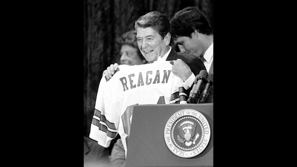 President Ronald Reagan responds to cheering supporters after being presented with a Dallas Cowboys jersey at a rally at the Republican National Convention in Dallas, Texas, on August 19, 1984.