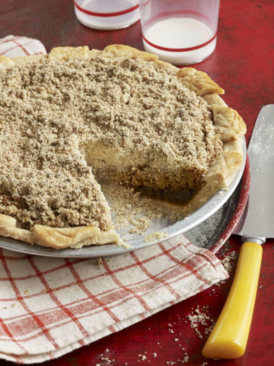 shoofly pie in a metal pie plate with a slice removed and a pie server next to it