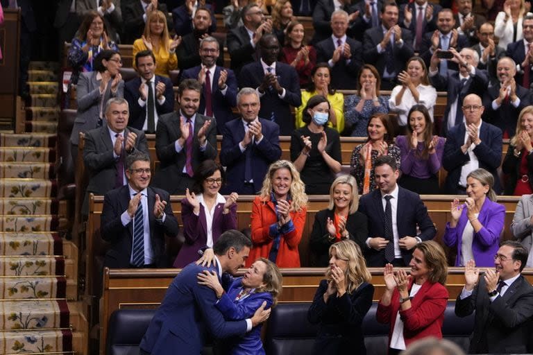 Pedro Sánchez, abajo a la izquierda, abraza a la vocepresidenta en funciones y ministra de Economía de España, Nadia Calviño, después de que fuera elegido por una mayoría absoluta