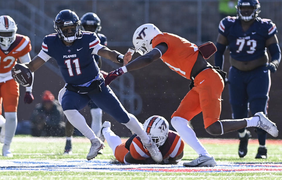 Liberty quarterback Johnathan Bennett (11), left, keeps the ball away from Virginia Tech linebacker Keil Lawson during an NCAA college football game in Lynchburg, Va., Saturday, Nov. 19, 2022. (Paige Dingler/The News & Advance via AP)