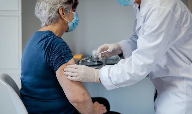 An older woman being vaccinated for COVID-19