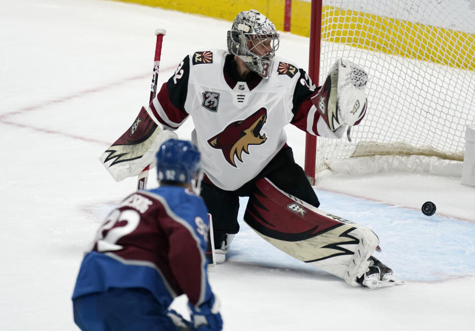 Colorado Avalanche left wing Gabriel Landeskog, front, scores the winniing goal against Arizona Coyotes goaltender Antti Raanta in overtime of an NHL hockey game Wednesday, March 10, 2021, in Denver. The Avalanche won 2-1. (AP Photo/David Zalubowski)