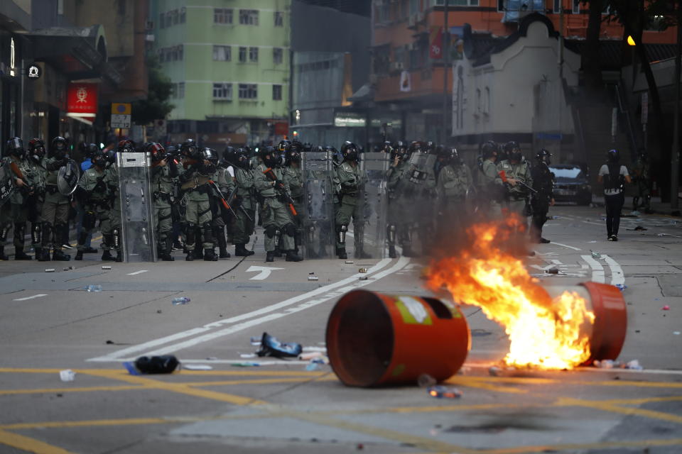 Anti-government protesters make fire to block traffic as they clash with police in Hong Kong, Tuesday, Oct. 1, 2019. Thousands of black-clad protesters marched in central Hong Kong as part of multiple pro-democracy rallies Tuesday urging China's Communist Party to 
