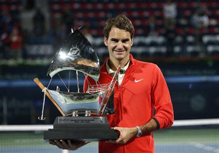 Roger Federer of Switzerland holds the trophy after defeating Tomas Berdych of the Czech Republic in their men's singles final match at the ATP Dubai Tennis Championships, March 1, 2014. REUTERS/Ahmed Jadallah