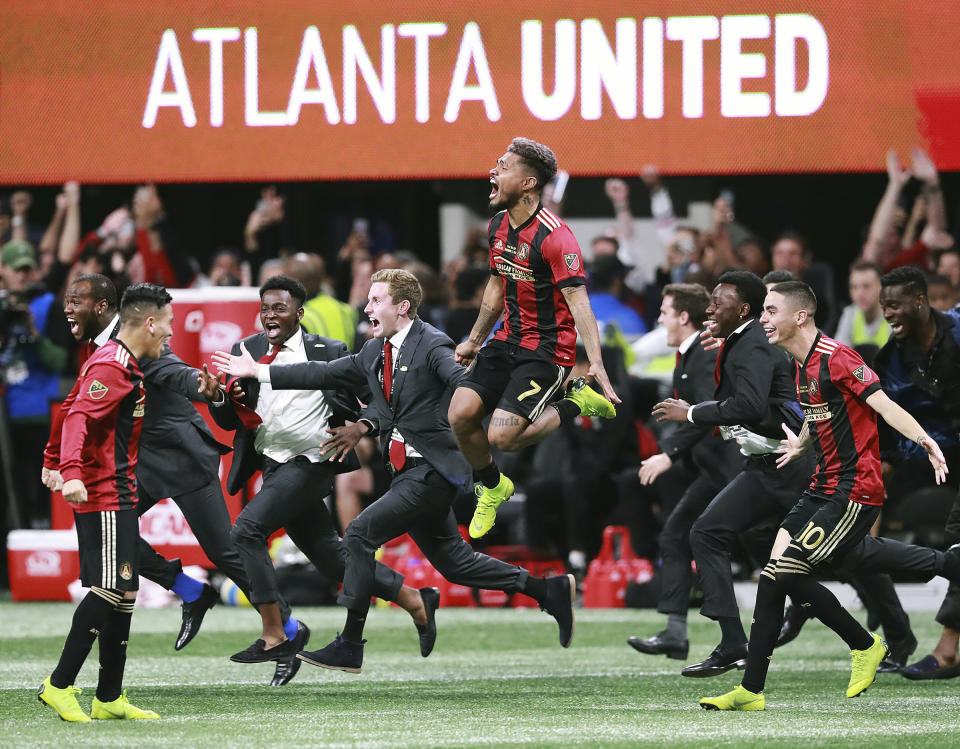 Atlanta United's Josef Martinez (7) leaps in the air and Miguel Almiron (10) charges the field celebrating their 2-0 defeat of the Portland Timbers in the MLS Cup championship soccer game, Saturday, Dec. 8, 2018, in Atlanta. (Curtis Compton/Atlanta Journal-Constitution via AP)