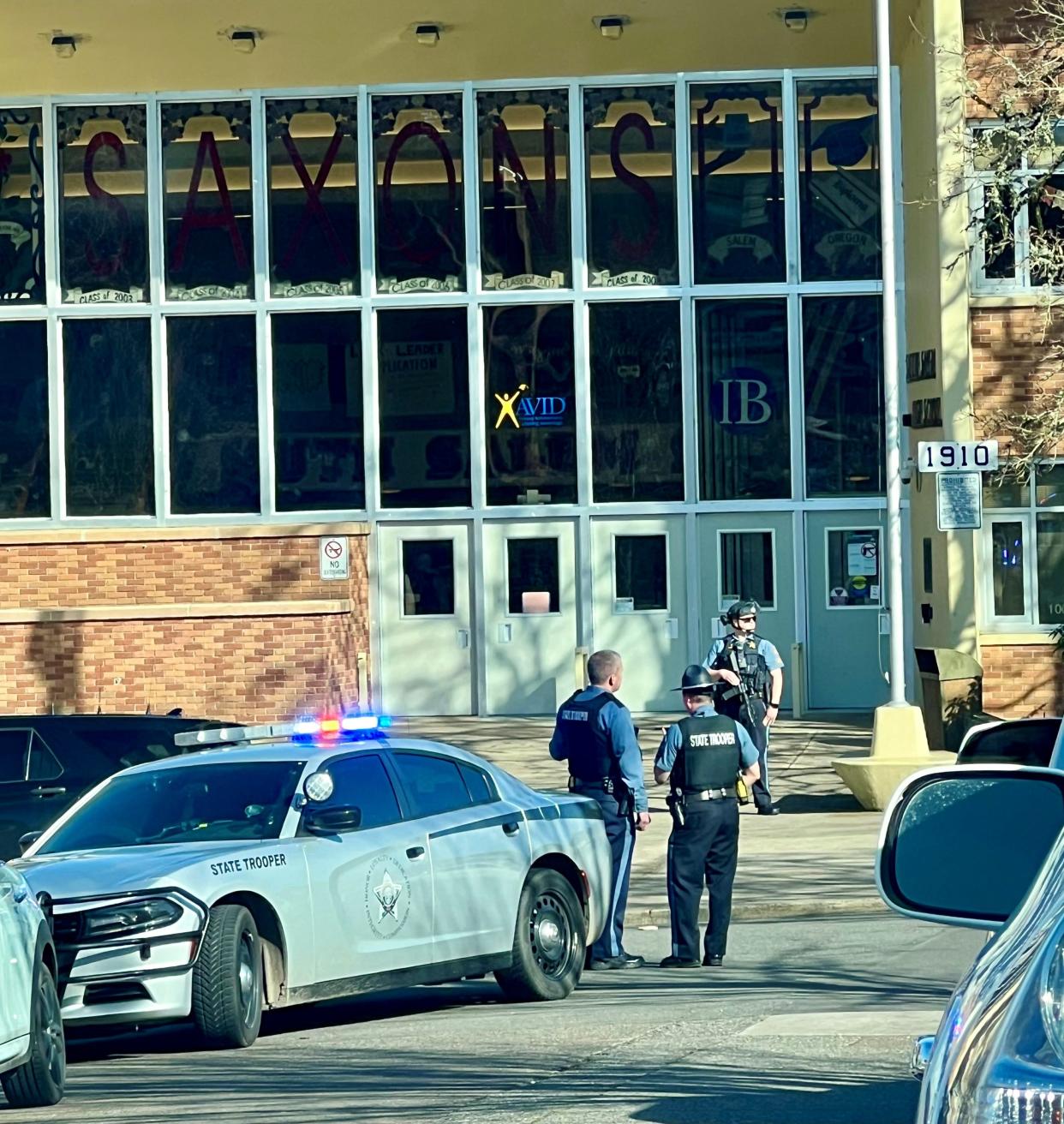 Police surround the entrance of Salem Salem High School on Thursday after a shooting at nearby Bush's Pasture Park. Both the teenager charged in the shooting and the deceased 16-year-old were enrolled at the school.