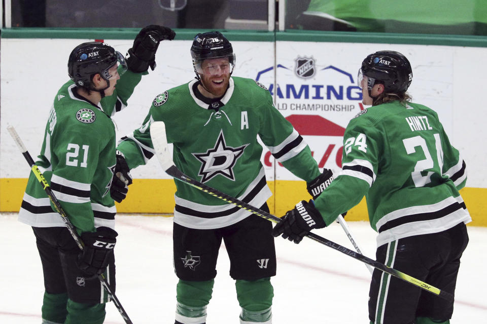 Dallas Stars' Jason Robertson (21) and Roope Hintz (24) celebrate a third-period goal by Joe Pavelski (16) against the Columbus Blue Jackets during an NHL hockey game Thursday, April 15, 2021, in Dallas. (AP Photo/Richard W. Rodriguez)