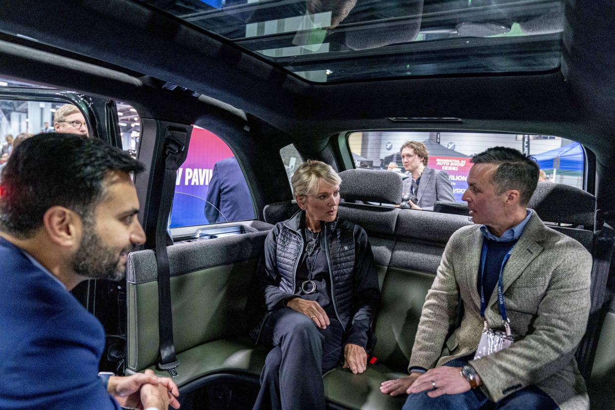 Energy Secretary Jennifer Granholm, center, and White House national climate adviser Ali Zaidi, left, speak to a company spokesman as they sit in a Canoo all electric SUV during a visit to the Washington Auto Show in Washington, Wednesday, Jan. 25, 2023. (AP Photo/Andrew Harnik)