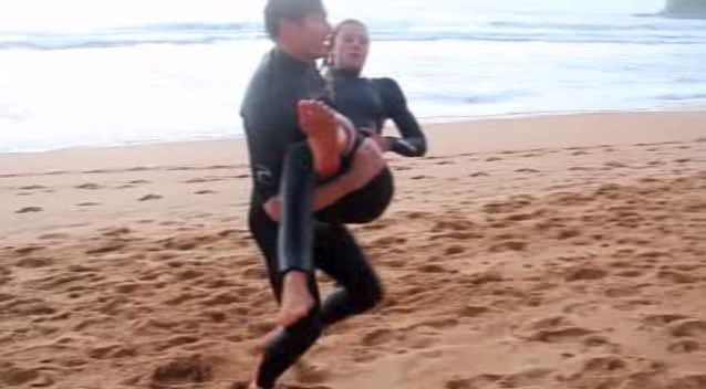 Kirra-Belle Olsson was carried up the beach by her friend after realising her foot had several gashes from where a shark bit her. Photo: 7News